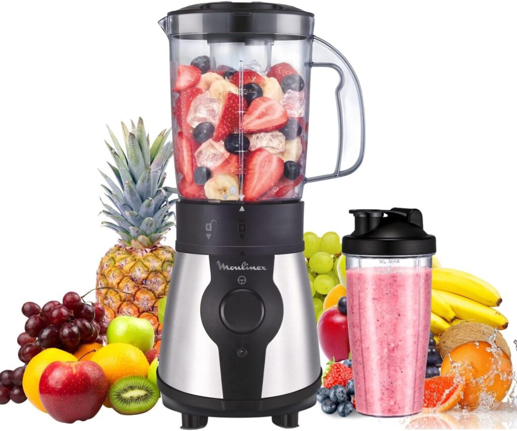 Batidora de vaso Moulinex con fresas y arándanos dentro y muchas frutas alrededor y un vaso con batido de color rosa